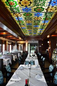 un comedor con mesas y un techo de vidrieras en Landmark Suites en Los Mochis