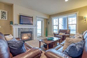 a living room with leather furniture and a fireplace at Heron's View at Bridgeport in Seaside