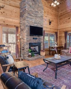 a living room with a stone fireplace with a tv at FALL SPECIAL! NERF Party, Pool, HotTub, Pet Friendly in Sevierville