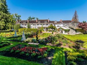 a large house with a garden in front of it at Crown Mansion Boutique Hotel & Villas in Qualicum Beach