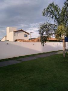 a white fence with a palm tree in a yard at Casa Temporada BV Capitolio in Capitólio