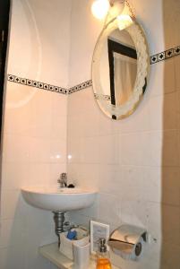 a bathroom with a sink and a mirror at Estudio Taller de Tejas Colonia B&B in Colonia del Sacramento