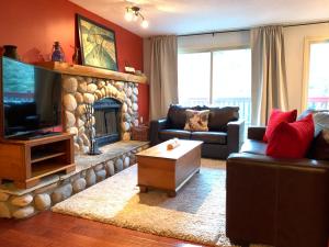 a living room with a couch and a fireplace at Panorama Mountain Resort - Horsethief Lodge with Fairmont Creek in Panorama
