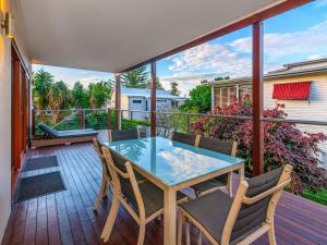 a patio with a glass table and chairs on a deck at Seagrass House in Yamba