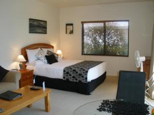 a bedroom with a bed and a table and a couch at Andrea's Bed & Breakfast in Whitianga