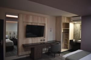 a living room with a tv and a bed at Hotel Frontiere Tijuana in Tijuana