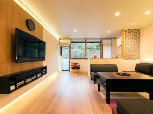 a living room with a couch and a table and a tv at House Hotel Kenrokuzaka in Kanazawa +17 photos