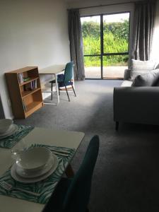 een woonkamer met een bank en een tafel bij Te Harinui - Peaceful rural escape in Tauranga