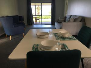 una sala de estar con una mesa con platos. en Te Harinui - Peaceful rural escape, en Tauranga