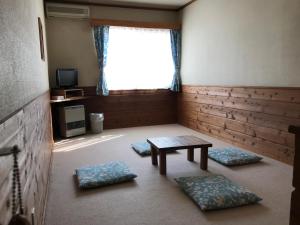 a room with a table and two pillows and a window at Pension Oz in Yuzawa