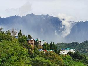 un grupo de casas en una colina con montañas en el fondo en THE CLOUD KINABALU- Chalet en Ranau