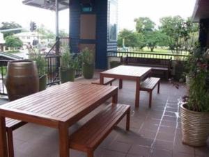 twee houten banken op een patio bij Aspect Central in Cairns