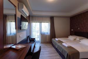 Pokój hotelowy z łóżkiem i biurkiem z biurkiem w obiekcie Vén Diófa De Lux Panzió w Segedynie +37 zdjęć