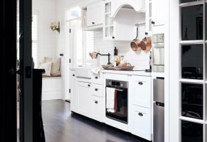 a white kitchen with white cabinets and a sink at The Blackwood Sassafras in Sassafras