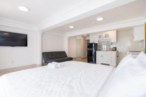 a bedroom with a large white bed and a kitchen at Homestay coco in Vung Tau