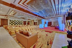 The Fern Leo Resort & Club - Junagadh, Gujarat في جوناغاد: قاعة احتفالات كبيرة فيها مجموعة من الكراسي