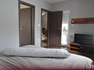 a bedroom with a bed and a flat screen tv at Apartments Lapaž in Sveti Martin na Muri