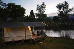 een tent aan de oever van een meer bij Thara Hidden Camp in Khao Kho