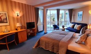 a hotel room with a bed and a television at Saar Galerie in Saarburg