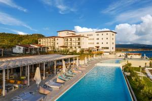 a hotel with a swimming pool and chairs and umbrellas at Mount Athos Resort in Ierissos