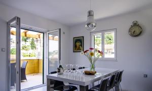 une salle à manger avec une table, des verres et une horloge dans l'établissement Villa Green Garden, à Splitska