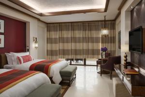 a hotel room with two beds and a flat screen tv at InterContinental Durrat Al Riyadh Resort & Spa, an IHG Hotel in Riyadh