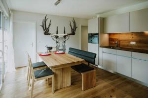 a kitchen with a wooden table with antlers on the wall at Ferienwohnung im Chalet Alpenrose in Adelboden