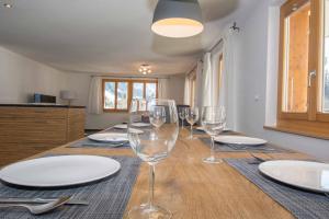 a table with wine glasses and plates on it at Schützenrain 1. Stock in Adelboden