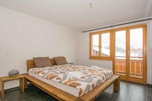 a bedroom with a bed and a large window at Schützenrain 1. Stock in Adelboden
