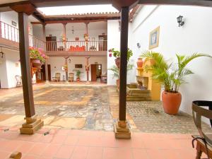 an empty courtyard with potted plants in a building at Casa del Carmen - Villa de Leyva in Villa de Leyva
