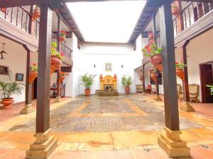 an empty courtyard of a building with potted plants at Casa del Carmen - Villa de Leyva in Villa de Leyva