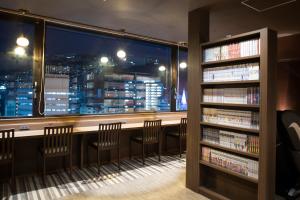 una biblioteca con vistas a la ciudad por la noche en Dormy Inn Premium Nagasaki Ekimae, en Nagasaki