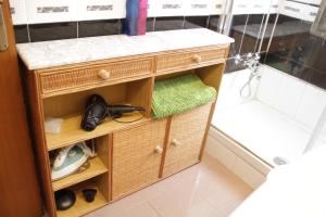 a small wooden cabinet in a bathroom with a shower at La Pintada in Valladolid