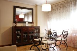 a dining room with a table and chairs and a mirror at La Pintada in Valladolid