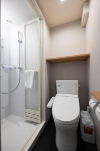 a bathroom with a white toilet and a shower at Dormy Inn Premium Nagasaki Ekimae in Nagasaki