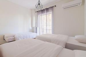 Dieses weiße Zimmer verfügt über 2 Betten und ein Fenster. in der Unterkunft Two Bedroom Apartment in Chalandri with Balcony in Athen