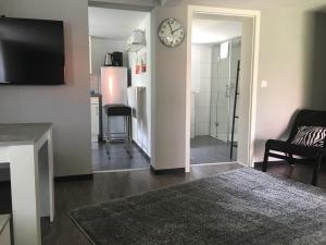 a living room with a clock on a wall at Haus Lindenteichblick 1 in Atzenhausen