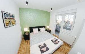 a bedroom with a large bed and a window at Apartment Jana 2 in Sombor