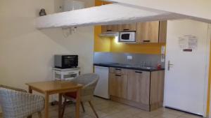 a small kitchen with a table and a microwave at Le Petit Séguret in Le Puy en Velay
