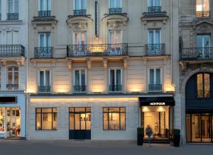 un edificio con una mujer caminando delante de él en Montfleuri, en París