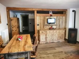 a dining room with a wooden table and a television at Maison Perriail Vda Gressan n 0029 in Gressan