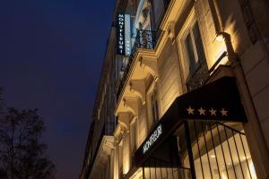 a building with a sign on the side of it at night at Montfleuri in Paris