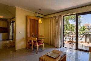 加藤達拉特索的住宿－Okeanis Golden Resort，一间带桌子的客厅和一个阳台