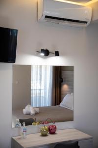 una camera d'albergo con letto e specchio di Αqua Dream Beach Apartment a Città di Kos