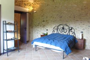 ein Schlafzimmer mit einem Bett mit einer blauen Bettdecke in der Unterkunft Luxury Casale Sabina Valley in Rocca Sinibalda + 52 Fotos