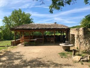 un padiglione con un tavolo e sedie in un campo di Güns Vendégház a Szigliget