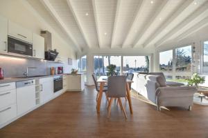 cocina y sala de estar con mesa y sillas en Ferienhaus Wiesenblick, en Ahlbeck