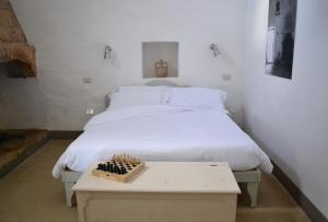 Una cama en una habitación con una mesa al lado en Masseria Caposella, en Ugento