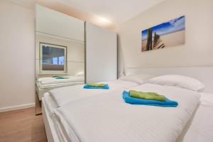 Un dormitorio con una gran cama blanca con dos toallas encima. en Ferienhaus Wiesenblick, en Ahlbeck