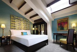 a bedroom with a large white bed and a desk at Aurum Royal in Singapore